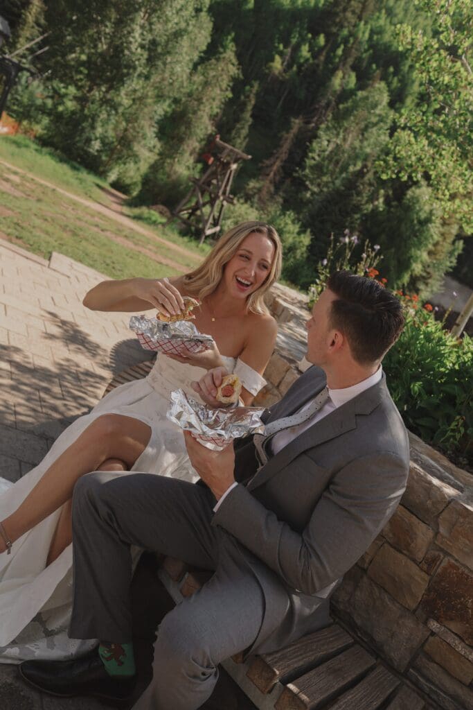 couple eating hotdogs on wedding day