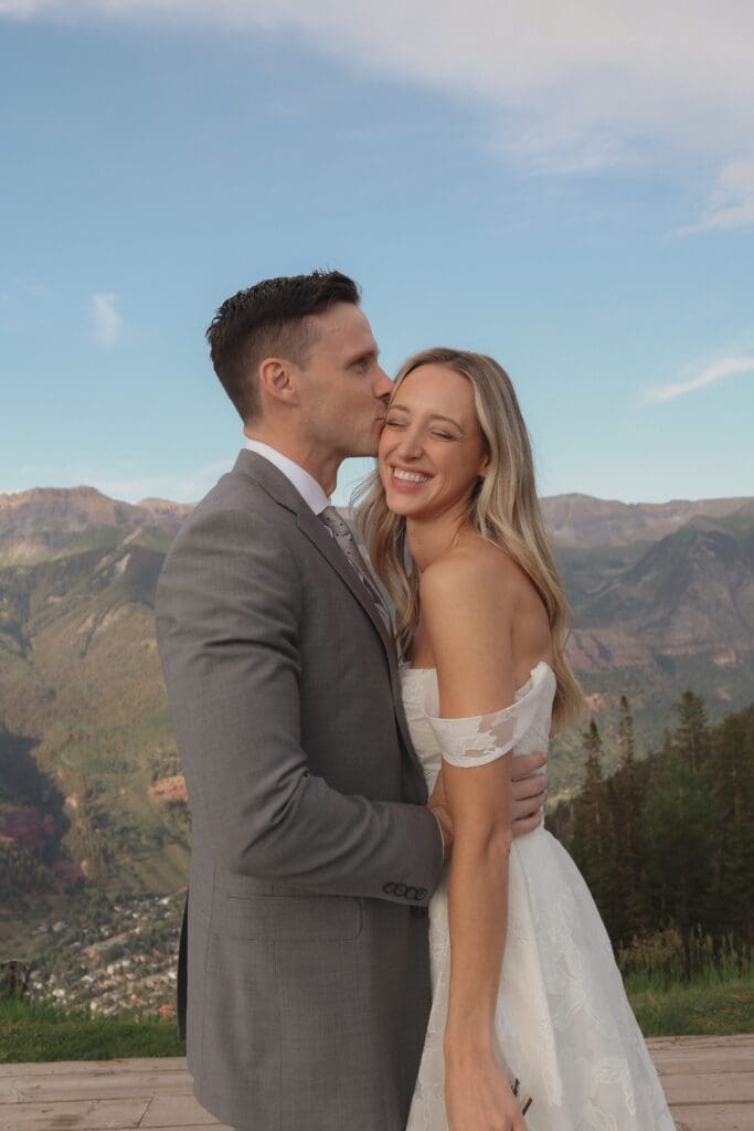 couple kissing at top of mountain